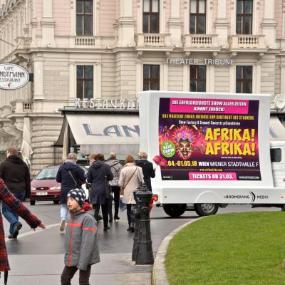 16 Bogen Plakat auf weissem Auto mit Werbung für Afrika! Afrika! im Großstadtverkehr