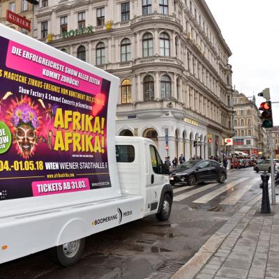 16 Bogen Plakat auf weissem Auto mit Werbung für Afrika! Afrika! im Großstadtverkehr