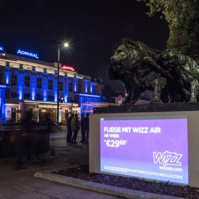 Projektion mit Werbung für Wizz Air auf Fassade in Großstadt in der Nacht